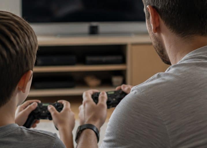 Close-up of a parent and child playing a video game together