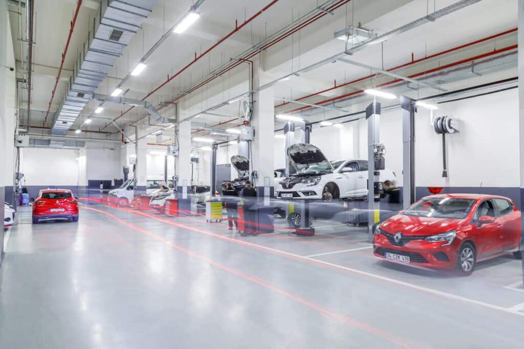 Bright, clean garage workshop with cars on the ramps