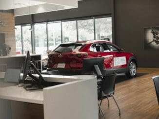Red car on display in a bright car showroom