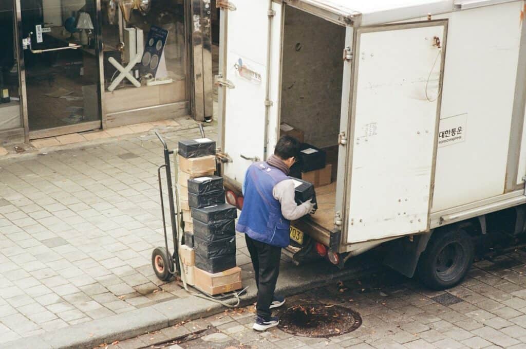 Man loading boxes from the back of a delivery lorry