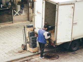 Man loading boxes from the back of a delivery lorry