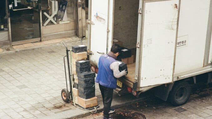 Man loading boxes from the back of a delivery lorry