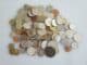 Pile of mixed coins from different countries on a white surface