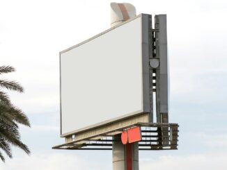 Blank white billboard on a tall post against a pale sky