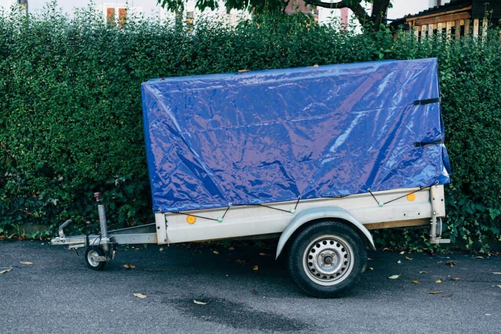 Small box trailer covered with a blue tarpaulin