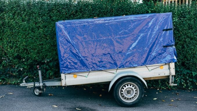 Small box trailer covered with a blue tarpaulin