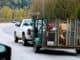 Pickup truck towing a loaded trailer along a road