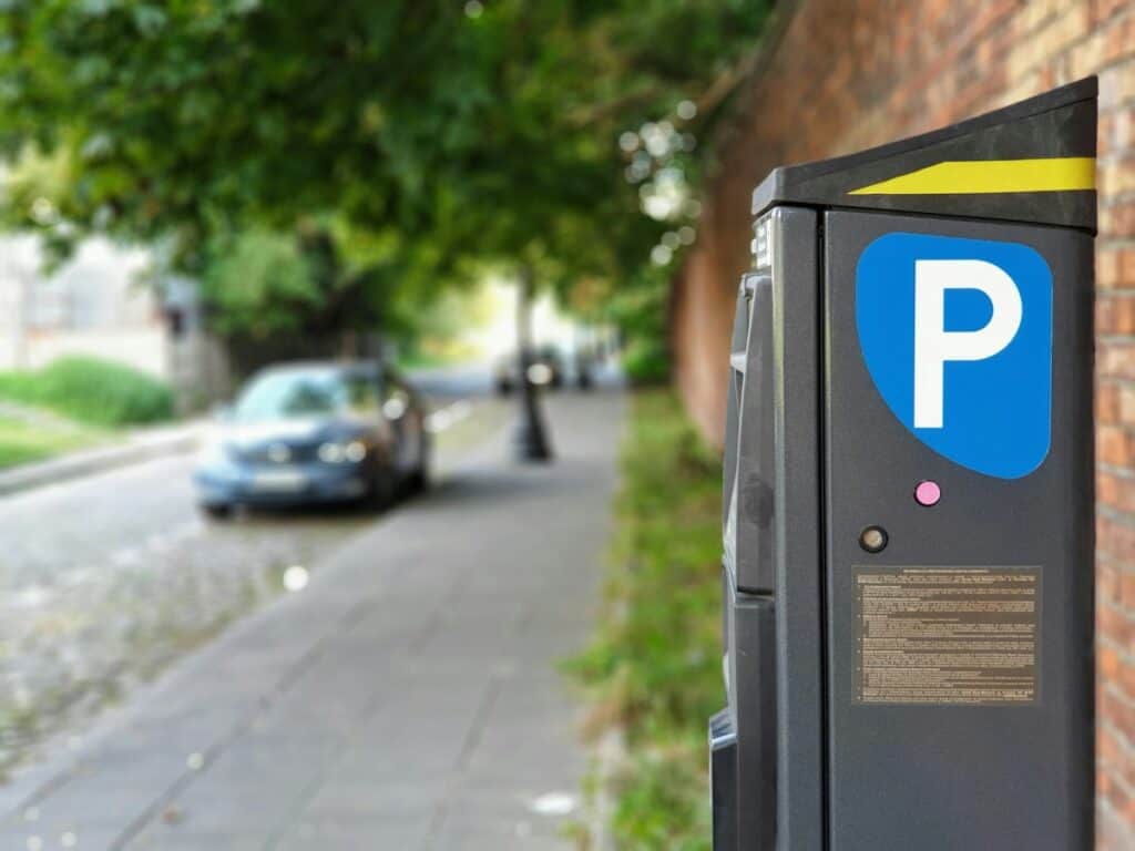 Car parked beside a pavement next to a parking meter