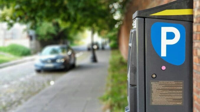Car parked beside a pavement next to a parking meter