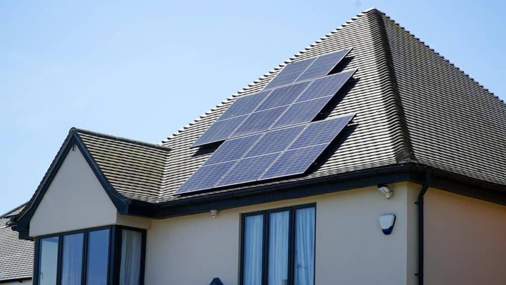 Modern house with dark solar panels on its sloping roof