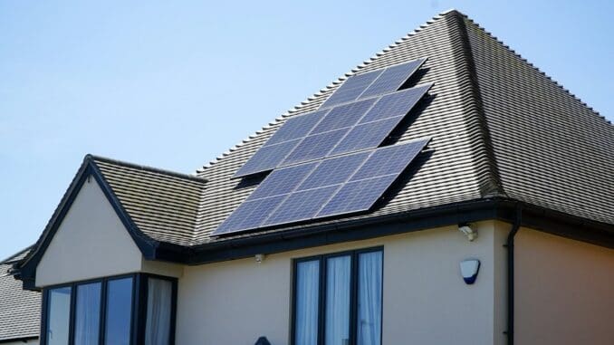 Modern house with dark solar panels on its sloping roof