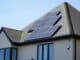 Modern house with dark solar panels on its sloping roof