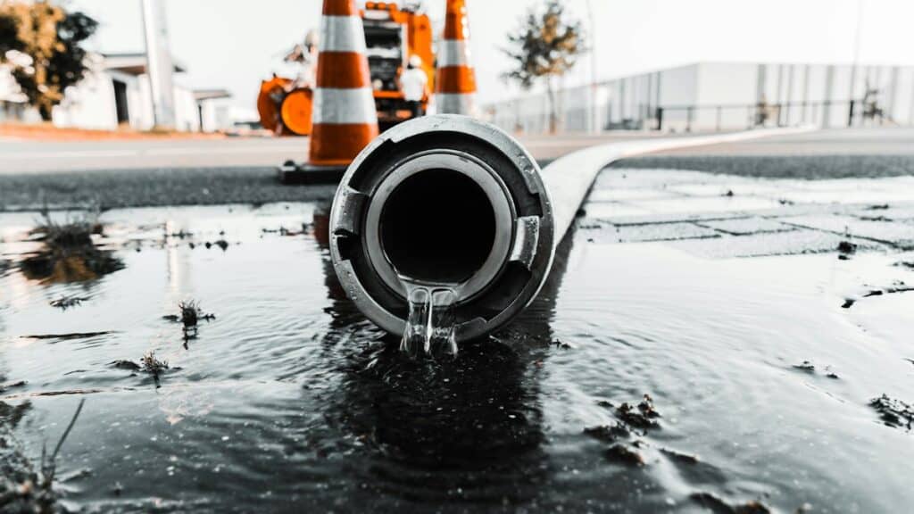 Water flowing from a large grey drainage pipe
