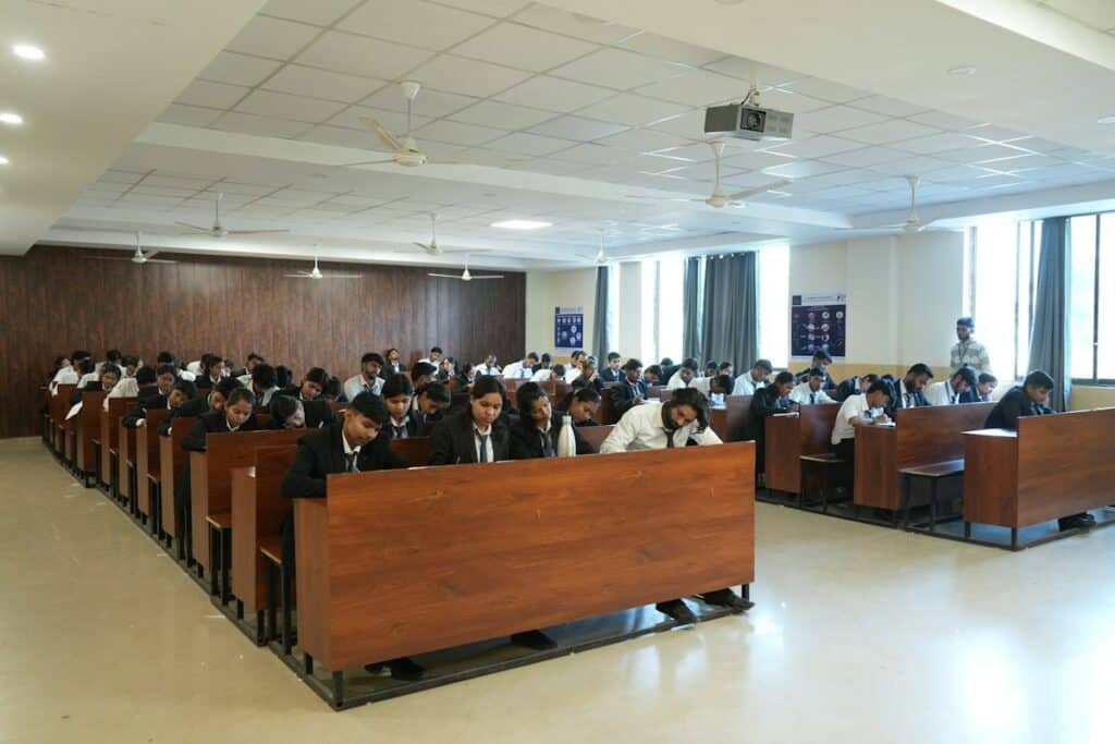 Rows of students seated at desks in a large hall