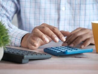 Person working on a calculator at a desk