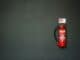 Red fire extinguisher mounted on a dark grey wall