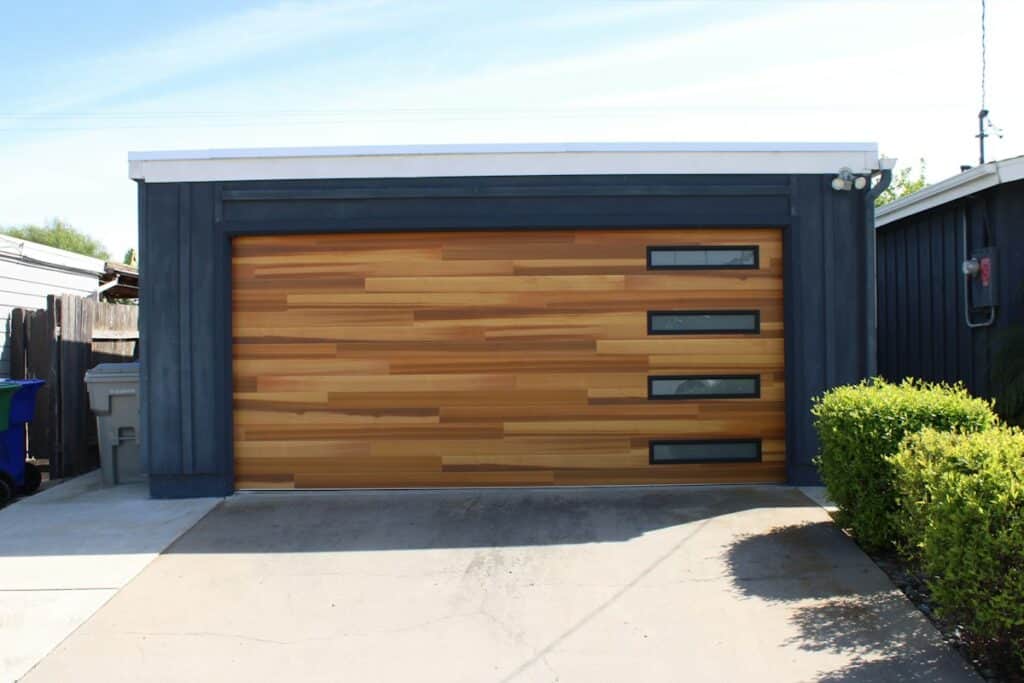 Modern wooden garage door on a dark-clad garage