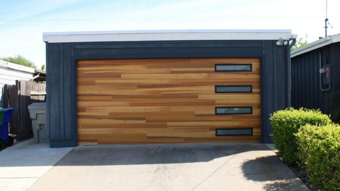 Modern wooden garage door on a dark-clad garage