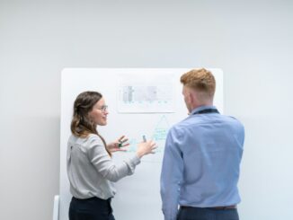 Two colleagues planning at a whiteboard