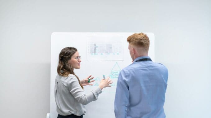 Two colleagues planning at a whiteboard