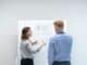 Two colleagues planning at a whiteboard