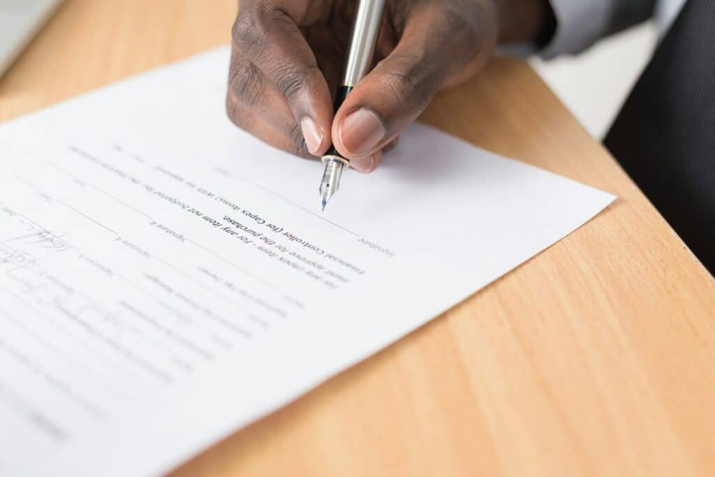 Hand signing a printed document with a fountain pen
