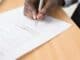 Hand signing a printed document with a fountain pen
