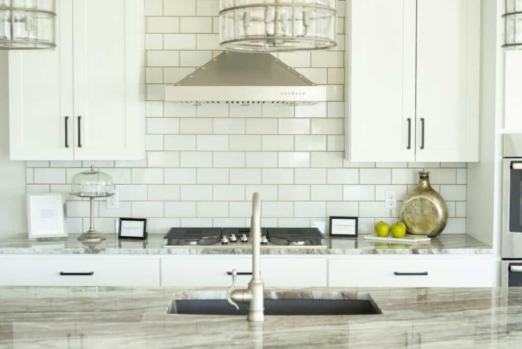 Bright white kitchen with metro-tiled walls and a range hood