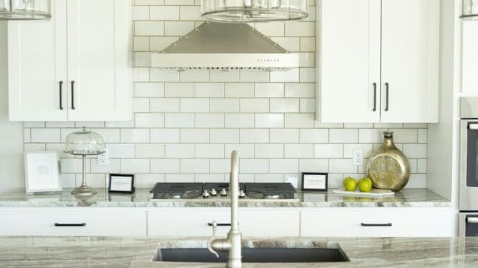 Bright white kitchen with metro-tiled walls and a range hood
