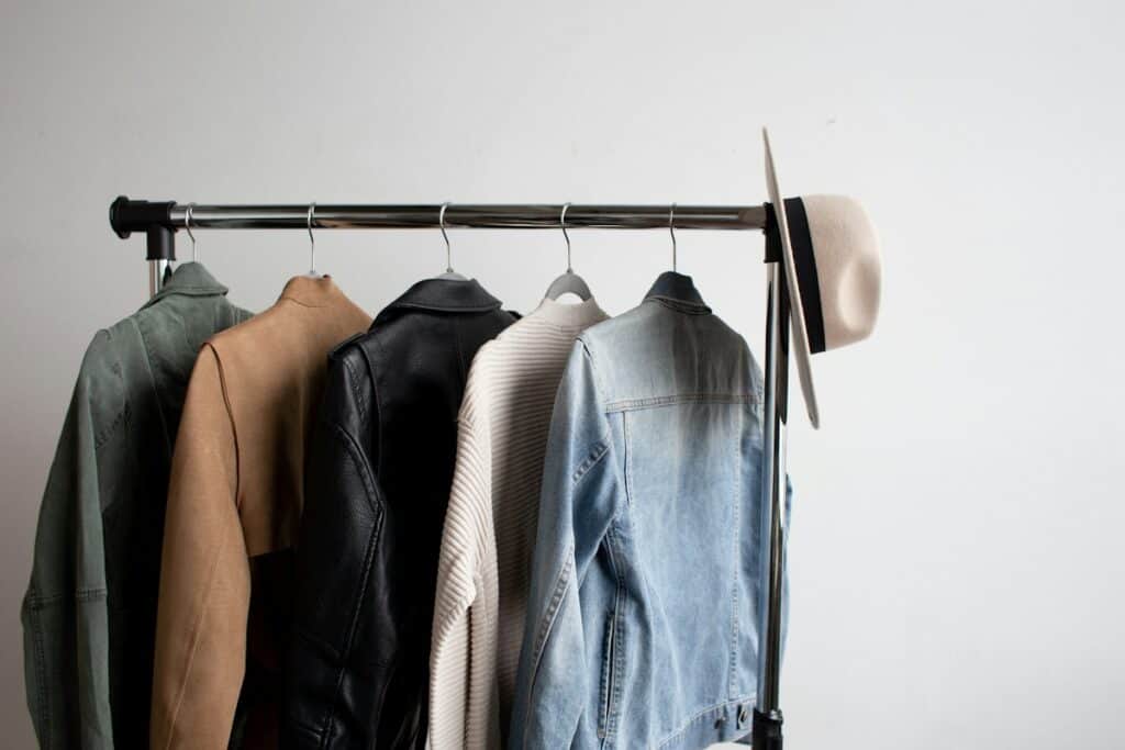 Clothes rail with jackets and shirts against a white wall