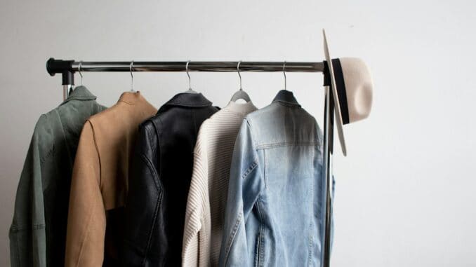 Clothes rail with jackets and shirts against a white wall