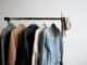 Clothes rail with jackets and shirts against a white wall