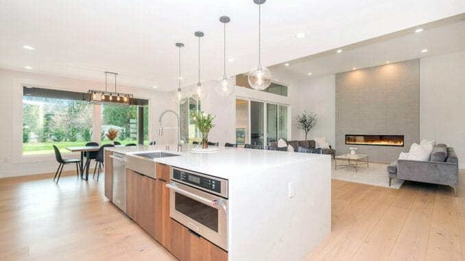 Bright open-plan kitchen with a white island and pendant lights