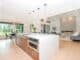 Bright open-plan kitchen with a white island and pendant lights