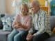 Older couple sitting together on a sofa in a bright living room
