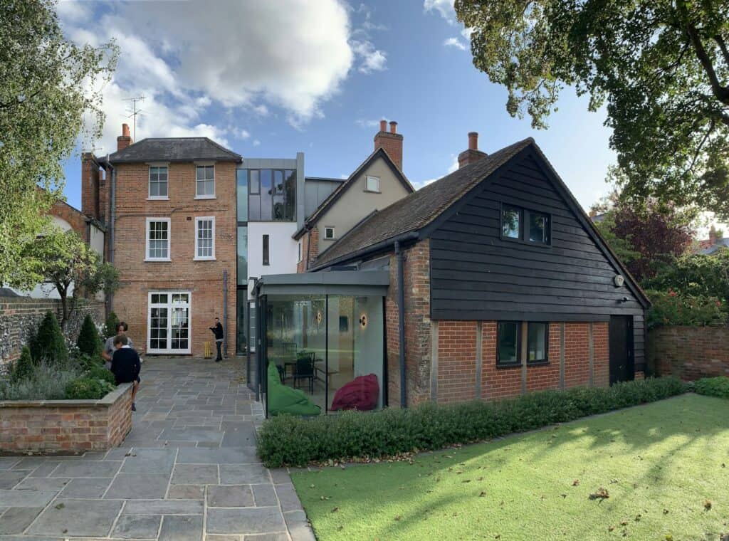 Red-brick period house with a modern glazed extension overlooking a garden