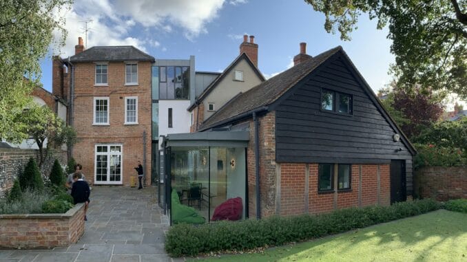 Red-brick period house with a modern glazed extension overlooking a garden